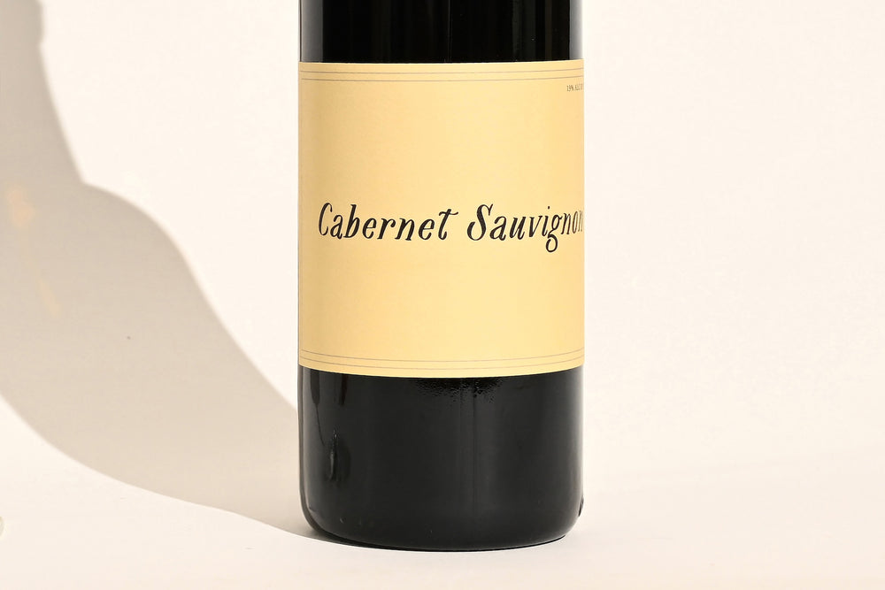 Close-up of Swick Wines 2023 Cabernet Sauvignon bottle label with cursive text on cream background and black lower section